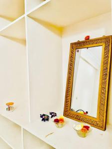 a mirror sitting on a shelf next to two bowls at Shanthi Home Stay in Puttaparthi