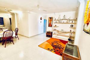 Shanthi Home Stay في بوتابارتي: غرفة معيشة مع طاولة وغرفة طعام