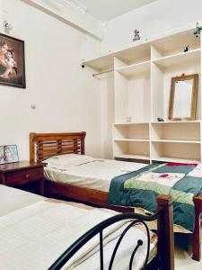 a bedroom with two beds and a mirror at Shanthi Home Stay in Puttaparthi