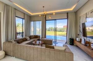 sala de estar con sofá grande y ventana grande en Where Luxury Meets Marrakech villa & private Pool, en Marrakech
