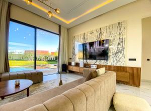 sala de estar con sofá y ventana grande en Where Luxury Meets Marrakech villa & private Pool, en Marrakech