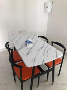 uma mesa de mármore branco com duas cadeiras e uma caixa sobre ela em ZDH Homestay em Kota Bharu