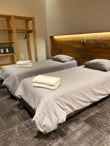 duas camas com toalhas por cima num quarto em EcoLofts Croacia 1028 em Punta Arenas