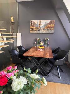 een eetkamer met een houten tafel en zwarte stoelen bij City-Penthouse mit 4 Terassen und Whirlpool in Wenen