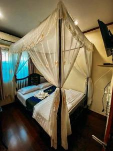 uma cama de dossel num quarto em 9 เฮ้าส์ เชียงคาน em Chiang Khan