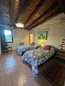 sypialnia z 2 łóżkami i krzesłem w obiekcie "Casa La Martina" naturaleza, sol y cielo w mieście Chacras de Coria