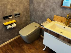 La salle de bains est pourvue de toilettes et d'un lavabo. dans l'établissement ウッドデザインパーク瀬戸, à Seto