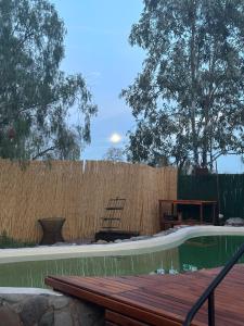 a backyard pool with a wooden deck and a fence at "Casa La Martina" naturaleza, sol y cielo in Chacras de Coria