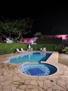 une petite piscine avec des chaises et un patio dans l'établissement Residencial Kahunas II, à São Sebastião