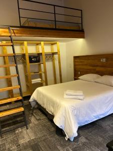 1 dormitorio con cama, escalera y literas en EcoLofts Croacia 1028 en Punta Arenas