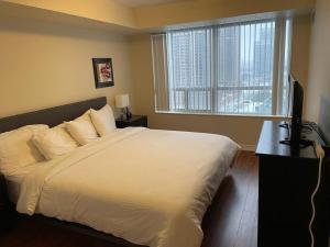 a bedroom with a white bed and a window at Platinum Suites Furnished Executive Suites in Mississauga +55 photos