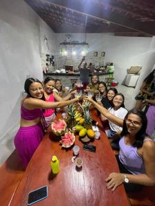 a group of women sitting around a wooden table at Chácara coqueiral in Estância