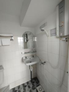 a white bathroom with a sink and a shower at Nhà Nghỉ SAO MAI in Ha Tien