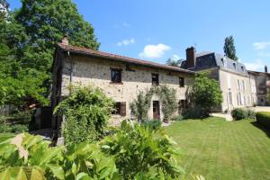 una antigua casa de piedra con un patio en Le masbareau, le vieux domaine en Royères-Saint-Léonard