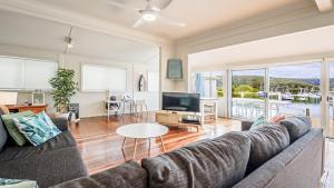 ein Wohnzimmer mit Sofa und Fernseher in der Unterkunft 'Classic Cottage on the Bay' by HolidayCo in Hardys Bay