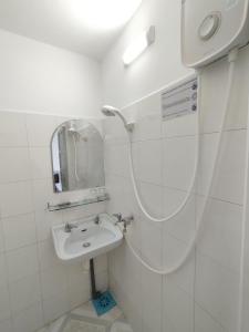 Baño blanco con lavabo y espejo en Nhà Nghỉ SAO MAI, en Hà Tiên