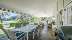 a screened porch with a glass table and chairs at 'Reverie' by HolidayCo in Hardys Bay