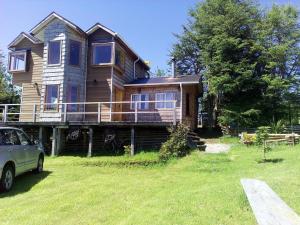 een huis met een auto ervoor geparkeerd bij Cabaña Rayen in Huillinco