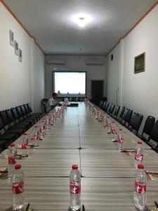 grand koetaradja permai hotel في Luengbata: طاولة طويلة عليها زجاجات ماء
