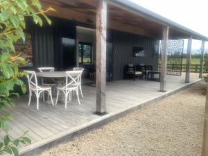 a wooden deck with a table and chairs on it at Bellevue Haven in Masterton