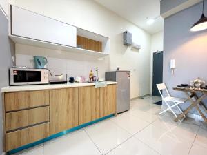 a kitchen with a microwave and a table in it at MesaHill Homestay, Nilai by S&T Homez in Nilai