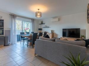 a living room with a couch and a tv and a table at Maison Moderne 3* avec Jardin et Clim à Biscarrosse Bourg - Près des Pistes Cyclables et Plages - FR-1-319-533 in Biscarrosse