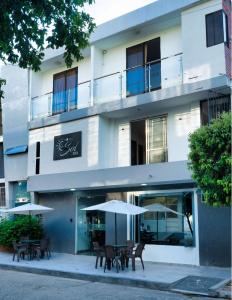 a building with tables and umbrellas in front of it at Hotel El Sol Inn in Aguachica
