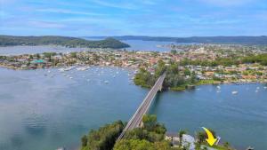 an aerial view of a river with a bridge and a city at 'Fair View On Daleys' by HolidayCo in Daleys Point