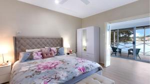 a bedroom with a large bed with flowers on it at 'Fair View On Daleys' by HolidayCo in Daleys Point