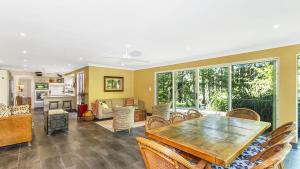 a living room with a wooden table and chairs at Wirreanda Retreat Acreage in Macmasters Beach