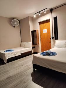 um quarto com 2 camas e uma porta de madeira em Hostal Machu Picchu Medellín em Medellín