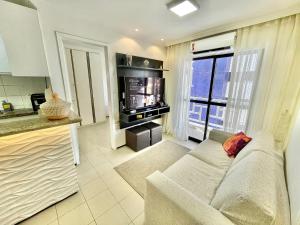 a living room with a couch and a television at Alessandra Residence | Meireles - CE in Fortaleza