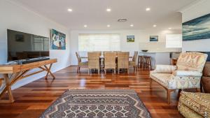 a living room with a piano and a dining room at 'Spacious Family Retreat' by HolidayCo in Killcare