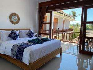 una camera con letto e balcone di The Pulau Bungalow a Nusa Lembongan