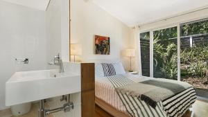 une salle de bain blanche avec un lit et un lavabo dans l'établissement 'Belvidere Cottage' by HolidayCo, à Pretty Beach