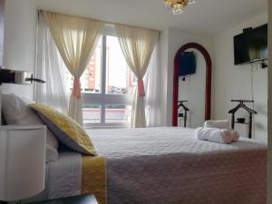 sypialnia z dużym łóżkiem i oknem w obiekcie Apto. acogedor cerca de todo lo mejor de la ciudad w mieście Manizales