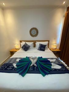 a bedroom with a bed with blue and green bows at The Pulau Bungalow in Nusa Lembongan