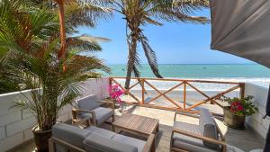 een balkon met stoelen en uitzicht op het strand bij Marina by Wynwood House in Máncora