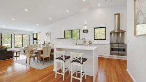 Una cocina y una sala de estar con mesa y sillas. en 'Space and Serenity at Pretty Beach' by Accom Holidays, en Pretty Beach