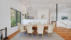 Un comedor con mesa y sillas en 'Space and Serenity at Pretty Beach' by Accom Holidays, en Pretty Beach