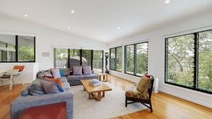 sala de estar con 2 sofás y ventanas en 'Space and Serenity at Pretty Beach' by Accom Holidays, en Pretty Beach 13 fotos más