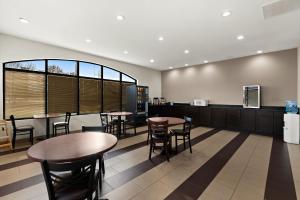 a restaurant with tables and chairs and a kitchen at Red Roof Inn Martinsburg in Martinsburg