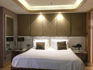 安吉利斯High Class 1BR at One Euphoria的卧室里有一张白色的大床和两张桌子