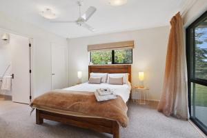 Un dormitorio con una cama grande y una ventana en Rose Cottage - Lake Coleridge Holiday Home, en Lake Coleridge