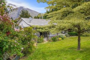 una casa con un patio con árboles y flores en Rose Cottage - Lake Coleridge Holiday Home, en Lake Coleridge