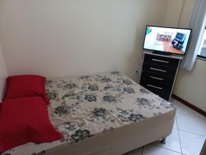1 dormitorio con 1 cama y TV de pantalla plana en Apartamentos Universo, en Imbituba