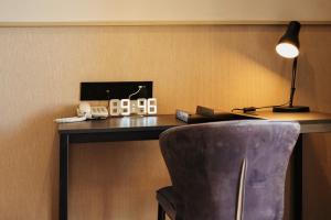 a room with a desk with a lamp and a chair at Resort Suites at Bandar Sunway in Petaling Jaya