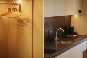 a kitchen with a refrigerator and a sink at Resort Suites at Bandar Sunway in Petaling Jaya