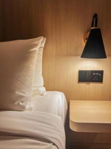 a bedroom with a bed and a lamp and a table at Resort Suites at Bandar Sunway in Petaling Jaya