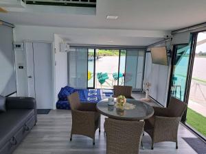 a living room with a table and chairs and a couch at แพรุ่งธารา ไชโย (Rungtara Houseboats) in Ban Bang Sala +25 photos